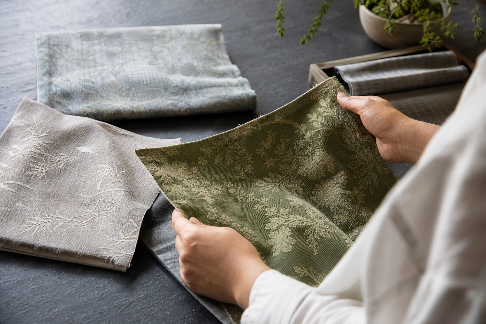 Designer reviewing green jacquard swatches by hand